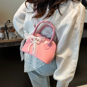 Schicke rosa Bowling-Tasche mit Spitzenschleife und Perlenanhänger, stilvolle Handtasche