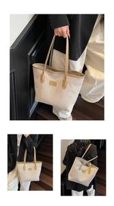 Detail of canvas tote bag with brown leather trim and shoulder straps on office stairs
