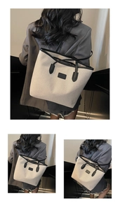 Detail of large canvas tote bag with black leather trim and contrasting neutral design