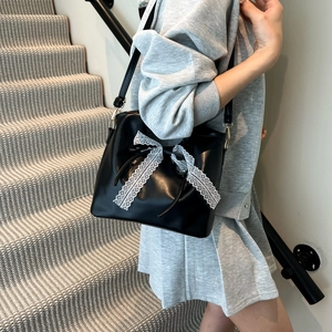 Minimalist black oil wax leather bucket bag with white lace bow detail for women