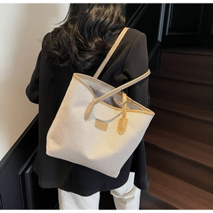 Canvas tote bag detail showing beige fabric with light brown leather trim and shoulder straps