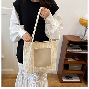Détail d'un cabas en paille tressée avec poche en cuir et poignées en corde souple