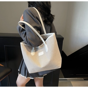 Detailed view of the contrast color canvas tote bag showing stitching and leather texture