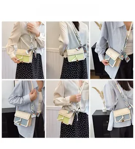 Detail of square crossbody bag featuring floral silk scarf wrapped around the shoulder strap