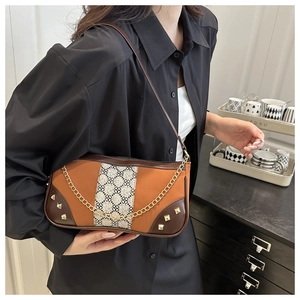 Detail of retro shoulder bag with leather patchwork and floral fabric with chain