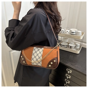 Detail showing vintage patchwork crossbody bag with metal chain and rivet decor