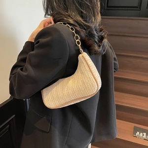Chic beige woven linen shoulder bag with gold chain strap shown on a model