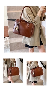Detail of vintage brown leather tote bag with unique baseball keychain on the zipper