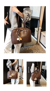 Detail of vintage brown leather tote bag with unique baseball glove pendant and zipper