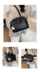 Detail showing the large capacity black leather tote bag with elegant handle and cute charms