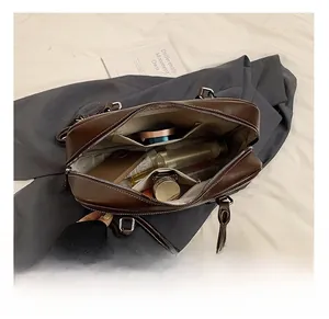 Top view of spacious interior of dark brown leather tote bag with cosmetic items