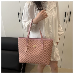 Detail of pink tote bag with M monogram print and golden logo worn by a model