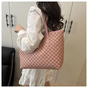 Detail of pink tote bag showing M-pattern monogram texture and gold rivet studs