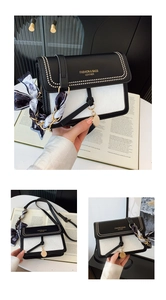 Detail of crossbody bag featuring black and white contrast leather with silk scarf handle