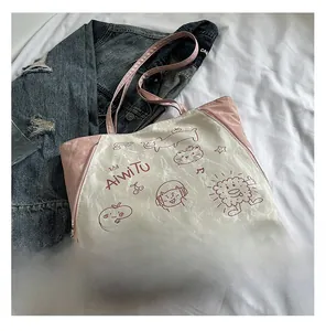 Detail of pink and beige tote bag with cartoon cat illustration and metal zipper trim