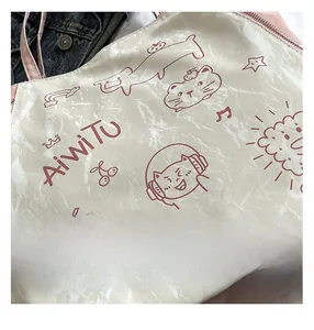 Detail of cream tote bag with red cartoon cat illustration and unique crinkled texture