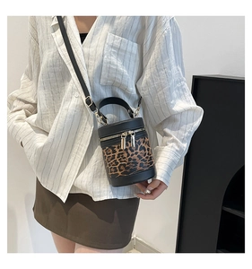 Detail view of fashion leopard print bucket bag with dual gold zippers and handles