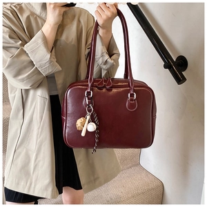 Detail of dark red vintage Boston bag featuring creative sports-themed baseball charms