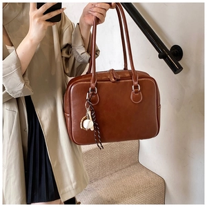 Retro brown leather tote bag with baseball charm shown in a mirror selfie for size scale