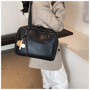 Detail of black tote bag with white contrast stitching and baseball charm