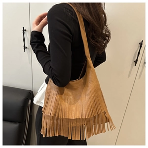 Detail of caramel fringe crossbody bag with retro bohemian style leather texture