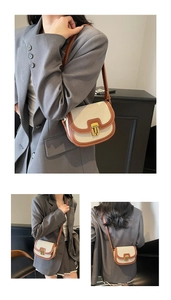 Detail of canvas saddle bag with brown leather trim and vintage gold metal clasp