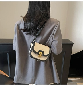 Detail view of retro saddle bag with contrast canvas and leather trim on grey blazer