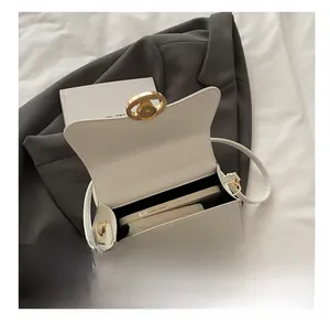 Detail view of cream white luxury handbag showing spacious interior and golden oval lock
