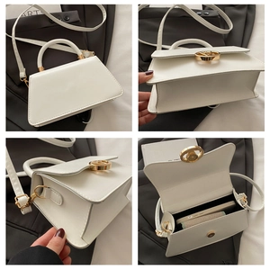 Detail view of a white leather handbag with golden round clasp and interior space