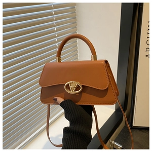 Detail view of the tan vintage handbag with gold oval metal buckle and smooth stitching