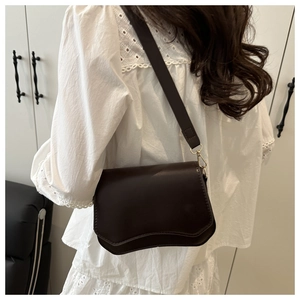French design crossbody square bag in dark coffee worn with a white lace shirt