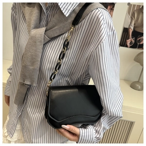 French retro shoulder bag with wavy edge design and mixed chain strap on striped shirt