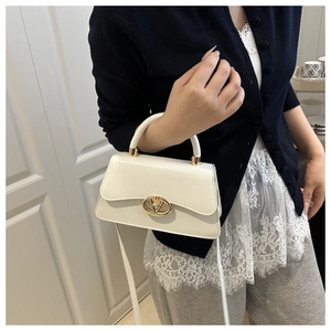 Détail du sac bandoulière en cuir blanc crème avec boucle en métal doré élégante