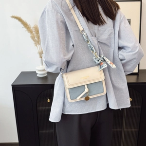 Creamy square crossbody bag with blue contrast panel and floral silk scarf strap detail