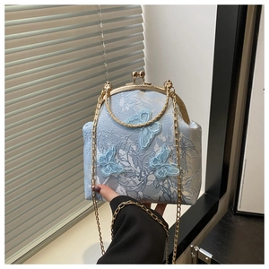 Detail of vintage blue lace bag with 3D butterflies and gold metal ring handle
