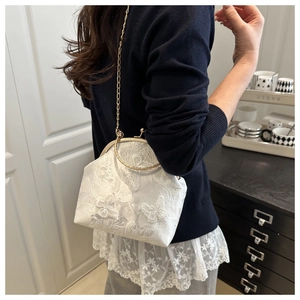 Lace handbag with butterfly embroidery and golden metal handles in a home setting