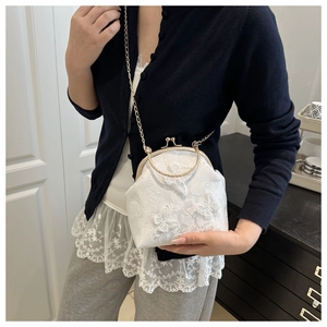 Close-up of white lace handbag with 3D butterfly embroidery and gold chain strap