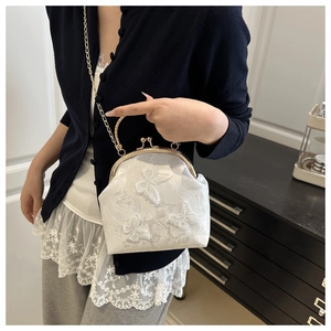 Détail du sac coquillage blanc avec broderie papillon 3D et fermoir vintage