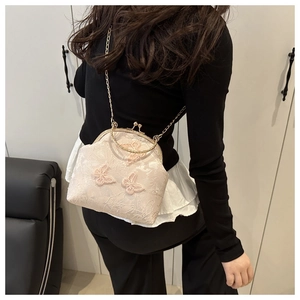 Detail of cream lace clutch with 3D butterfly embroidery and vintage metal frame clasp