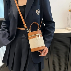 Fashionable bicolor canvas and brown leather bucket bag with top handle and strap