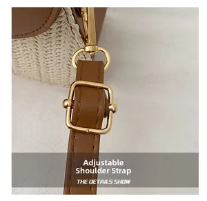Detail of adjustable leather strap with golden metal buckle on woven straw crossbody bag