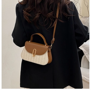 Detail of vintage straw woven bag with brown leather flap and golden metal clasp buckle