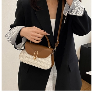 Détail d'un sac bandoulière en cuir marron et paille tressée porté par un mannequin