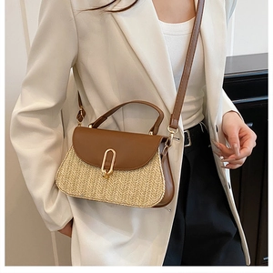 Detail of woven straw and brown leather crossbody bag with golden metal clasp