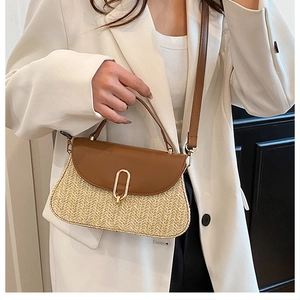 Détail d'un mini sac bandoulière en paille avec garniture en cuir brun et fermoir doré en U
