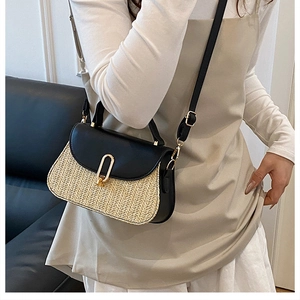 Détail du sac bandoulière en paille tissée avec rabat en cuir noir et fermoir doré