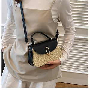 Gros plan d'un sac en paille tissée avec rabat en cuir noir et fermoir doré chic