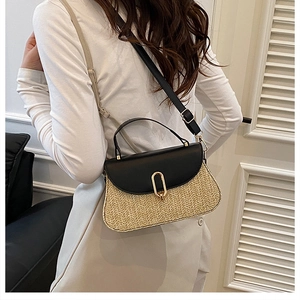 Détail du sac à main en paille tressée avec rabat en cuir noir et boucle dorée