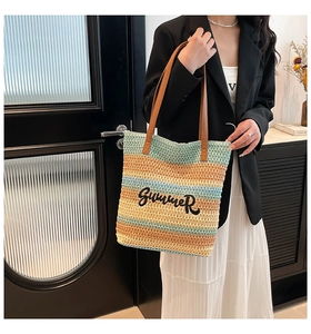 Detail of colorful striped woven bucket bag with Summer embroidery and leather strap