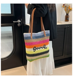 Close-up of colorful striped woven tote bag with Summer embroidery and leather handles